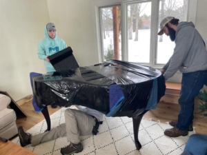Unique Movers team padding and wrapping a piano move in Little Falls, MN to Park Rapids, MN.