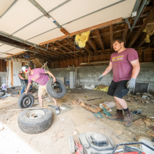 Junk removal of tires and debris from a residential garage near Monticello, MN, by two members of the Unique Movers crew.