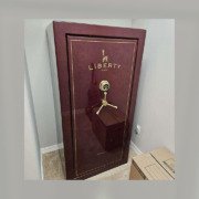 A large maroon gun safe that has been moved.