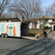 A mover loads items onto a moving trailer at a house.