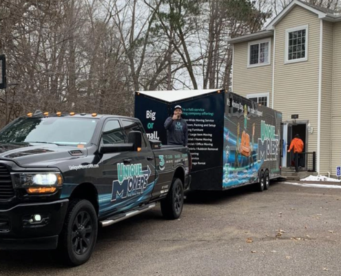 apartmentMistakes-SocialImage A moving truck and trailer parked outside of an apartment building.