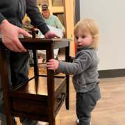 A child helping carry a side table during a move.