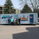 The Unique Movers apartment moving team is standing in front of a moving trailer outside an apartment building.