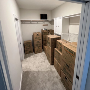 A stack of moving boxes in a bedroom closet.