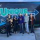 A couple and their dog with the Unique Movers team in front of a moving trailer.