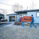 Two residential movers carry a couch from a house to the moving truck.