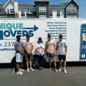 A family standing in front of a moving trailer.