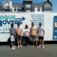 A family standing in front of a moving trailer.