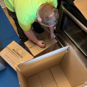 A Unique Movers team member packing and labeling boxes for a residential move.