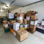 A stack of moving boxes packed up in a garage.